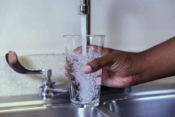 Sink faucet filling a glass of water